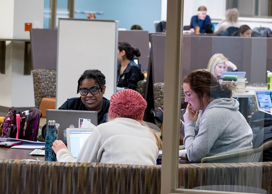 Students studying at a table in the library.